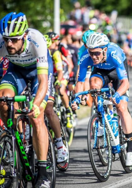 Ciclisti in gara su strada durante una competizione.