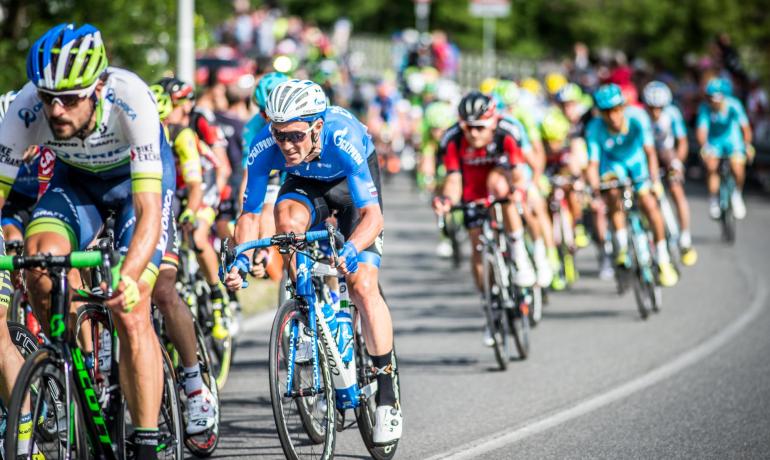 Ciclisti in gara su strada durante una competizione.